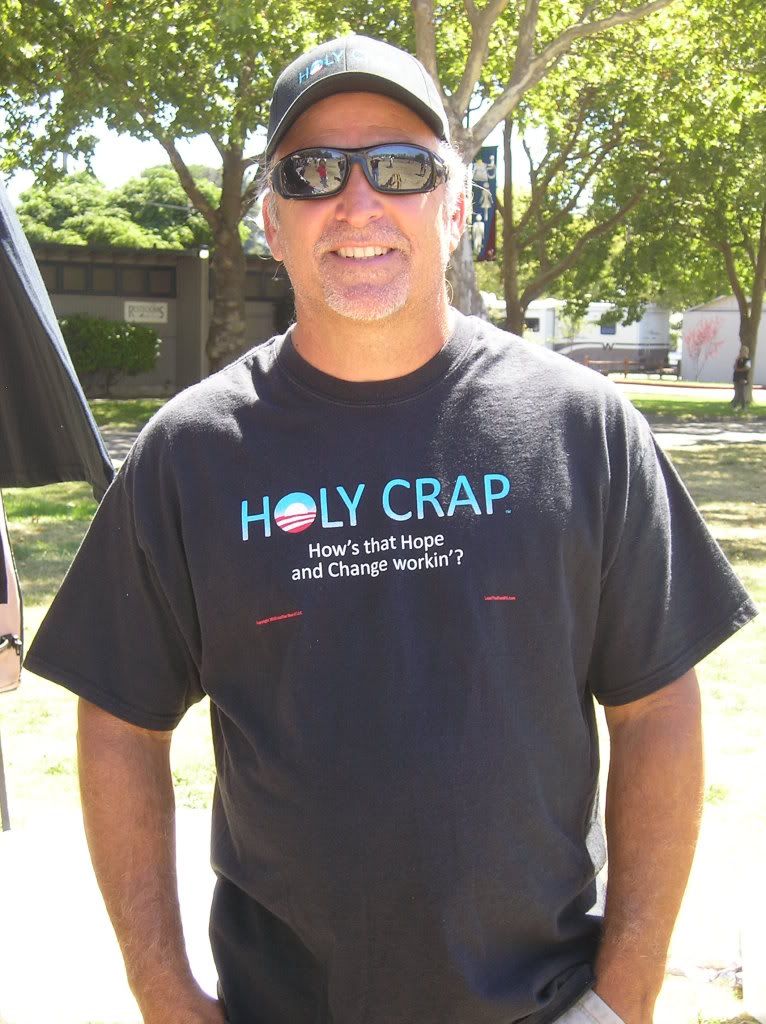 A Vendor Shows Off One of His T-Shirts